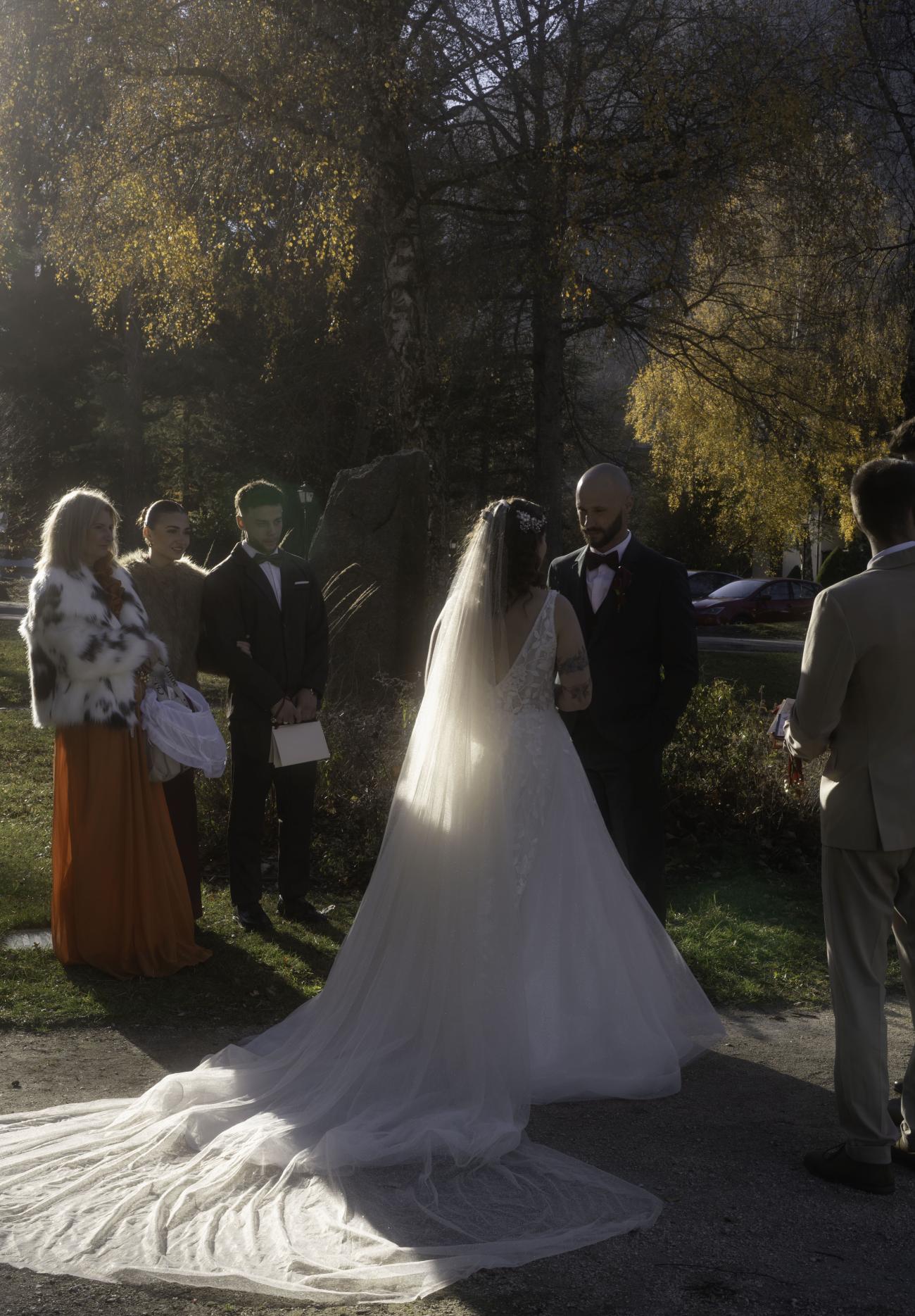 Sortie d'église lors d'un mariage en décembre à La Rochelle : couple de mariés sous une lumière d'hiver dorée et vaporeuse.