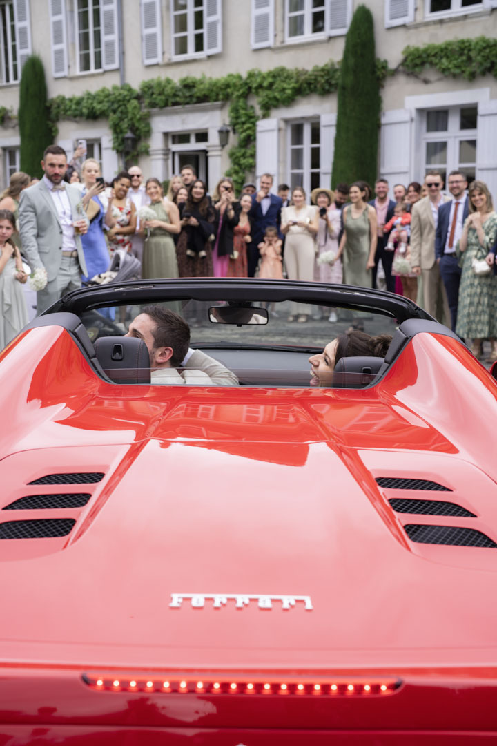 Mariage franco-anglais au Domaine de Monda : arrivée des mariés en Ferrari accueillis par les invités à Ayzac-Ost.